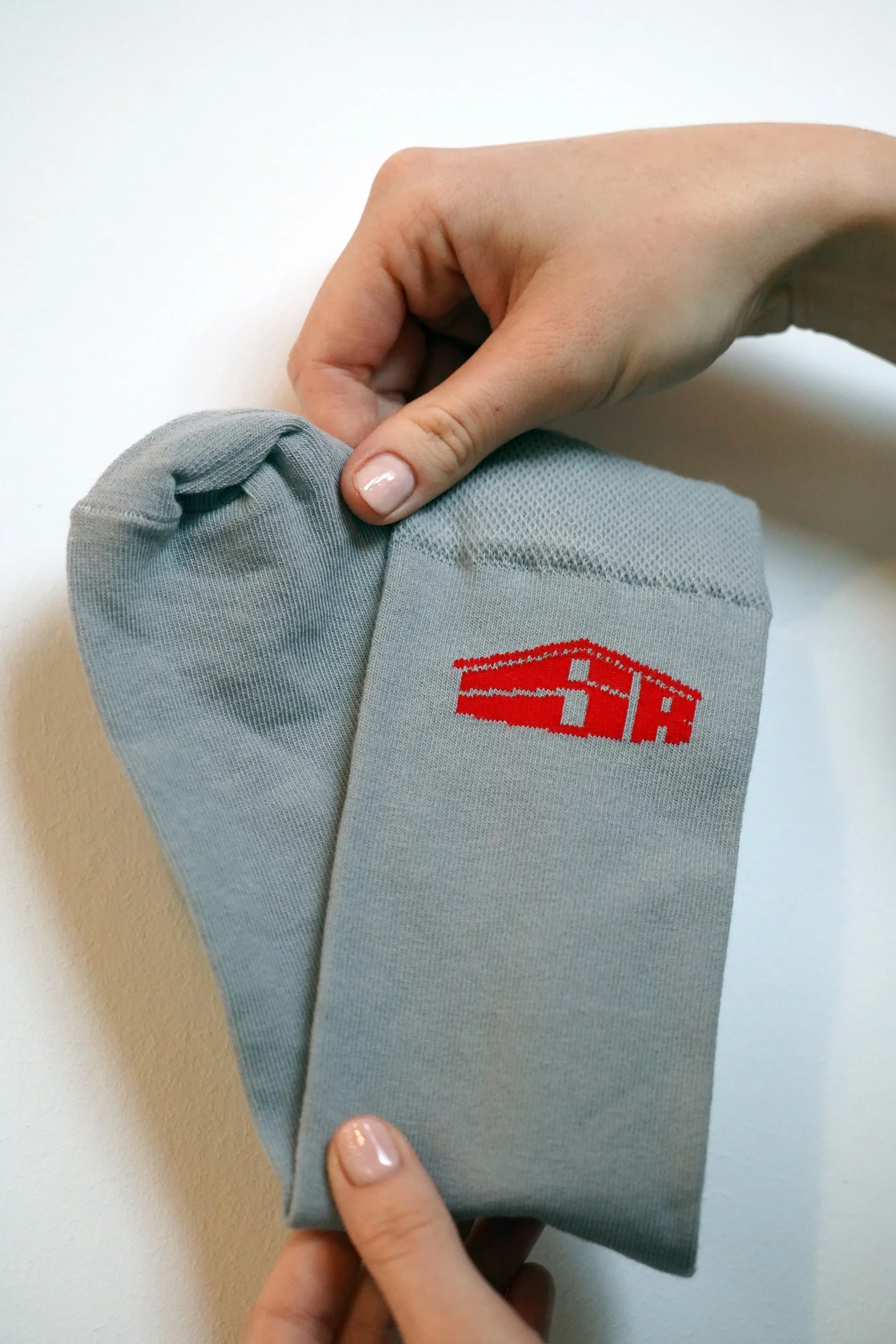 Grijze sokken met logo op maat — referentieproject klant